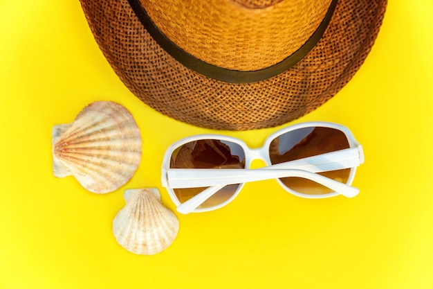 Sunglasses shell and retro hat on yellow background