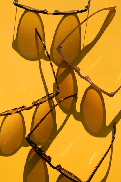 Sunglasses with long shadow on a brignt summer yellow background