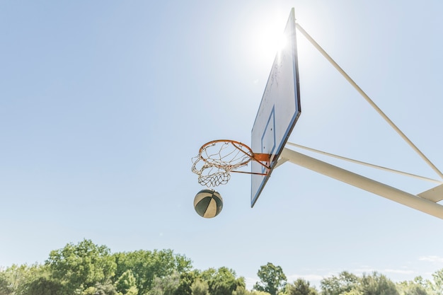 Sunlight over the basketball hoop against blue clear sky