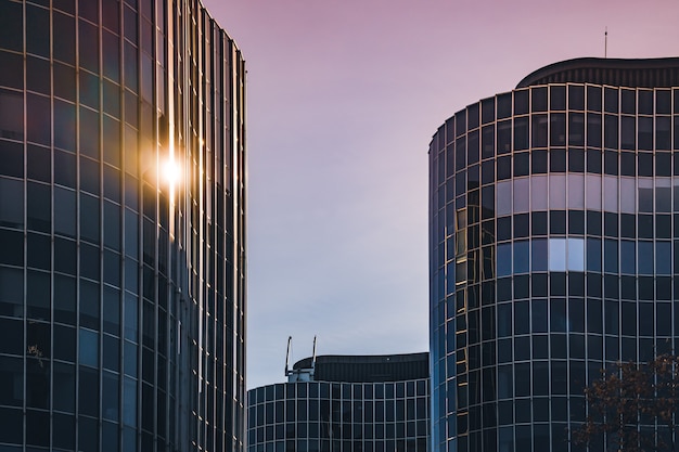 Sunlight reflecting on the curved glass facade of an office building