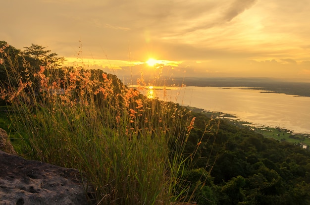 sunlight reflects the water surface and the grass is on mountains