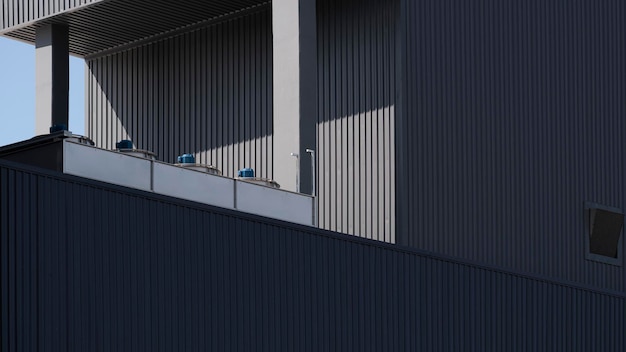 Sunlight and shadow on surface of air conditioner compressors on top of black industrial building