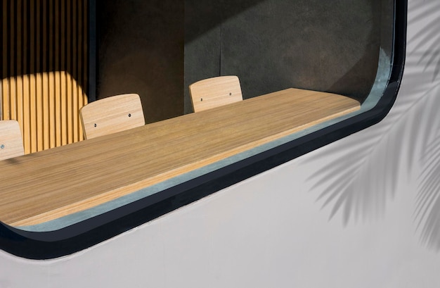 Sunlight shining through glass wall into wooden row table bar inside of vintage coffee shop