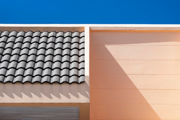 Sunlight on surface of brown awning tile on top of vintage house with blue sky