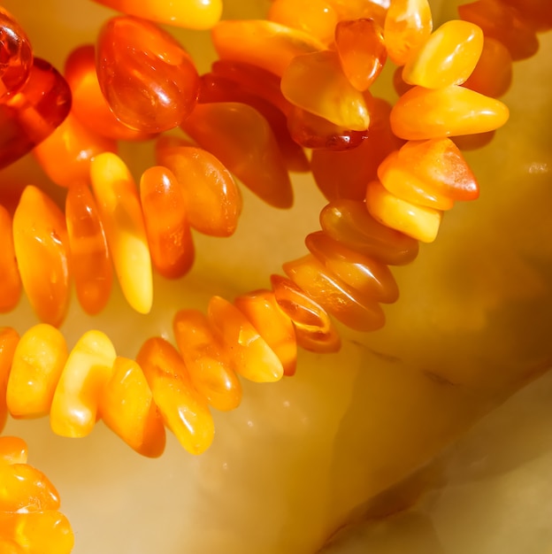 Sunny beads of fire amber natural gemstone background jewelry concept