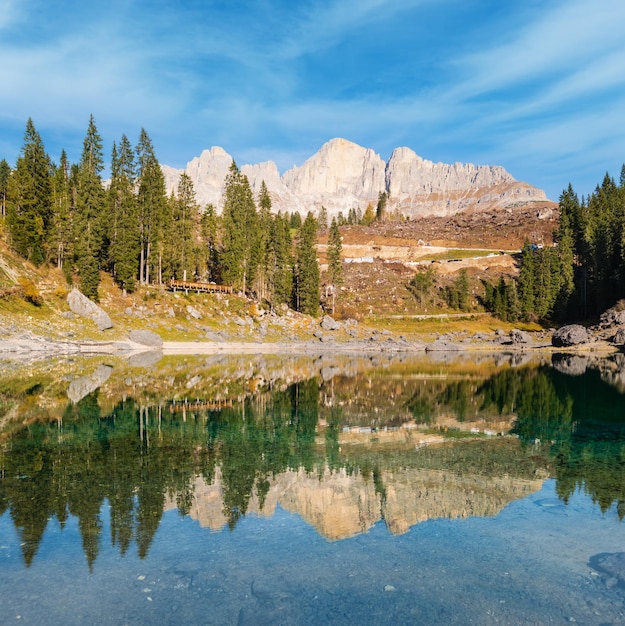 Sunny colorful autumn alpine Dolomites mountain scene Sudtirol Italy Karersee or Lago di Carezza view