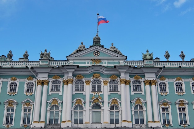 Sunny day in SaintPetersburg russian flag flying above facade of Hermitage State Museum