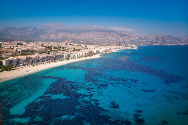 Sunny day, Summer, Spanish Mediterranean Sea Coast Landscape. Beach with turquoise water. Touristic sun and beach landmark in Comunidad Valenciana, Spain