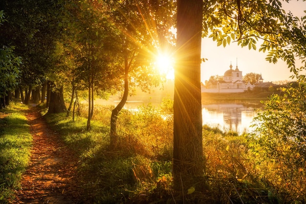 Sunny Morning landscape on the bank of the river and the temple in the distance in Ostrov in Pskov