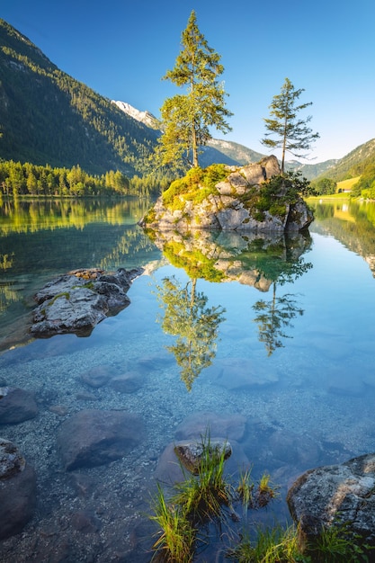 Sunny morning scenery on Hintersee Lake Beautiful scene of trees on rocky island Ramsau National park Berchtesgadener Land the Alps Bavaria Germany