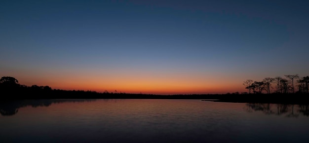 Sunrise at coast of the lake Blue sky and sun reflection on water Nature landscape in asian