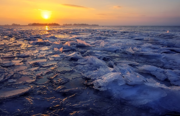 Sunrise and frozen sea. Beautiful winter landscape with lake in morning time.