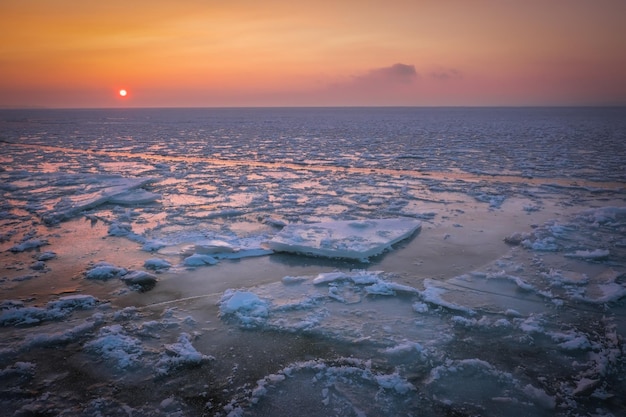 Sunrise and frozen sea Beautiful winter landscape with lake and red sun in morning time Daybreak