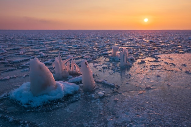 Sunrise and frozen sea Beautiful winter landscape with lake and red sun in morning time Daybreak