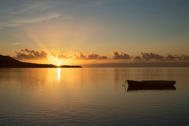 Sunrise in Mauritius with the sun in the background and a fishing boat in the foreground