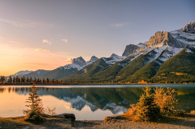 Sunrise on Mount Rundle with blue sky reflection on Rundle Forebay reservoir in autumn at Canmore, Canada