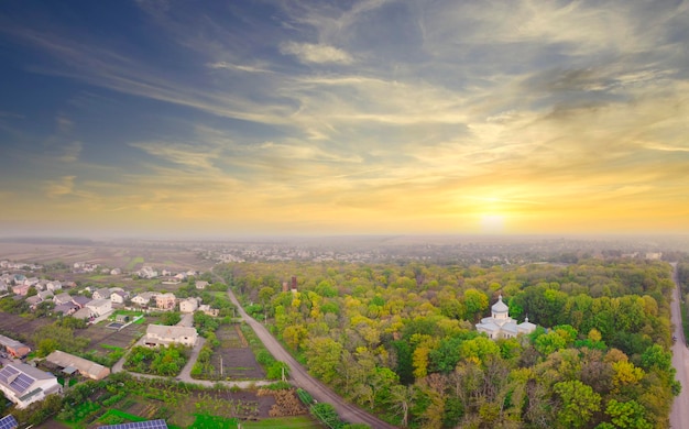 Sunrise over the park located in the village Fog over the trees and the church in the park