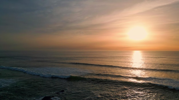 Sunrise sea rippling water beach aerial view dawn sky over dark serene ocean