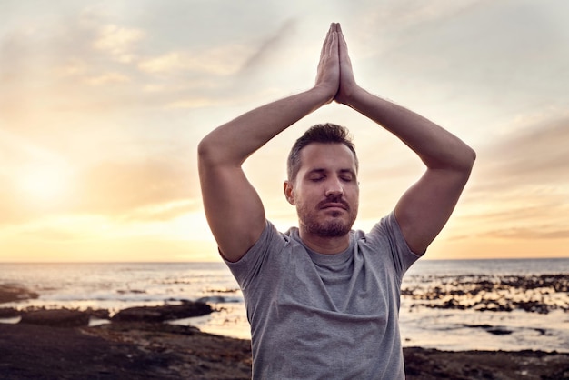 Photo sunrise yoga peace and man at the beach for mind wellness spiritual freedom and relax exercise by the ocean in bali zen meditation soul training and person at the sea for calm in the morning