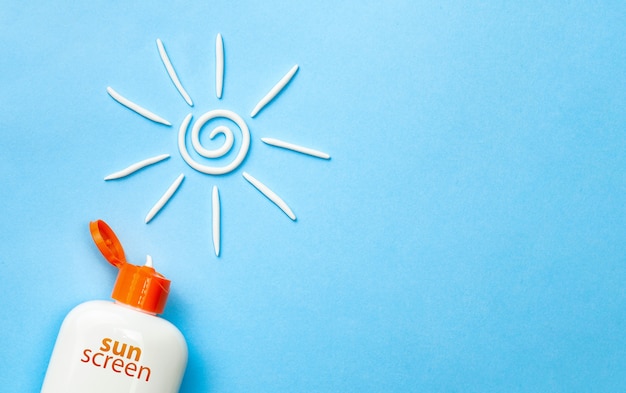 Sunscreen. Cream in the form of sun on blue background with white tube. Copy space for text.