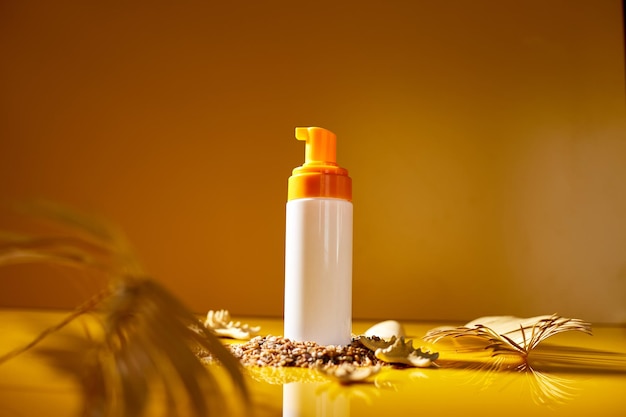 Sunscreen tube mockup with shells sand yellow background