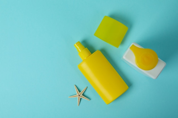 Sunscreens and starfish on blue isolated background