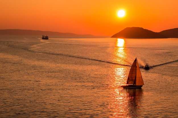 Sunset over the Adriatic Sea and its boats playing in the reflections at the entrance to the port of Split in Croatia