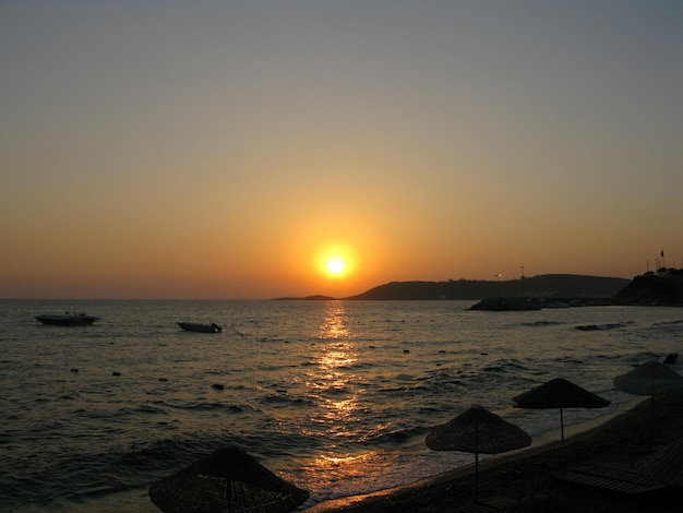 Sunset on the beach A calm sea with a sunset sky and the sun through the clouds