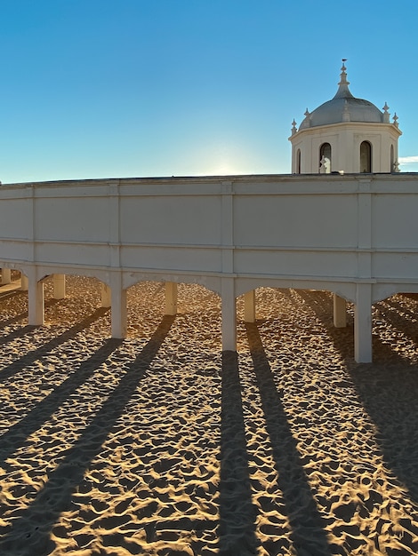 Sunset on the beach La Caleta with the sun behind an old wooden building in Cadiz Spain