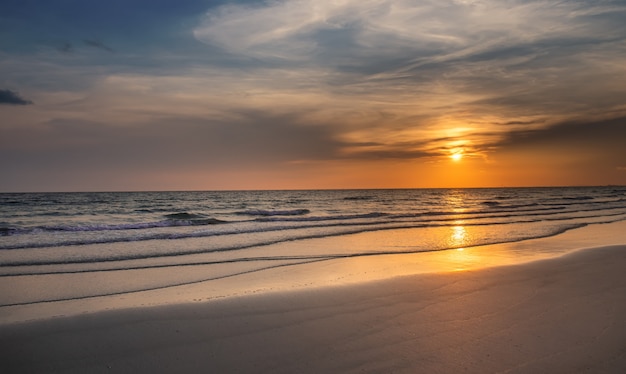 Sunset on the beach with the wavy sea