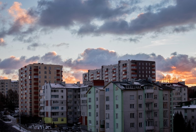 Sunset over city rooftops silhouettes residential quarters