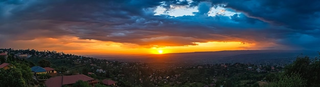 Photo a sunset over a city with a mountain in the background