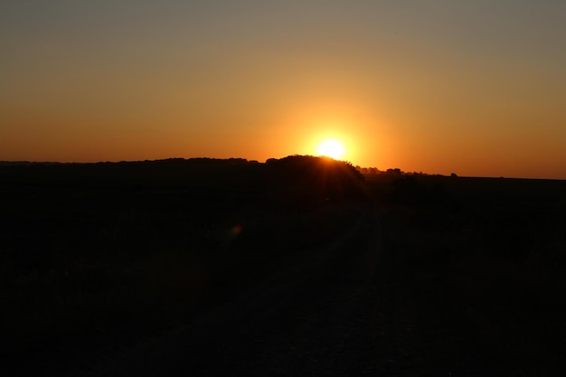 A sunset over a dirt road