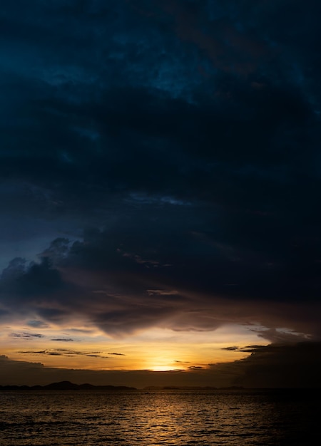 Sunset Dusk Sky in Evening with OrangeYellow and Dark blue colour by the sea Seaside with dramatic twilight landscape of Skyline and cloudVertical Romantic Sunrise in Summer