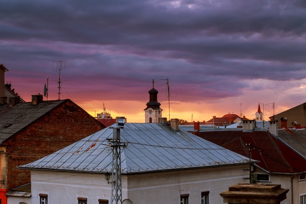 Sunset evening sky pink clouds of the roof of the houses of Uzhhorod city, Ukraine