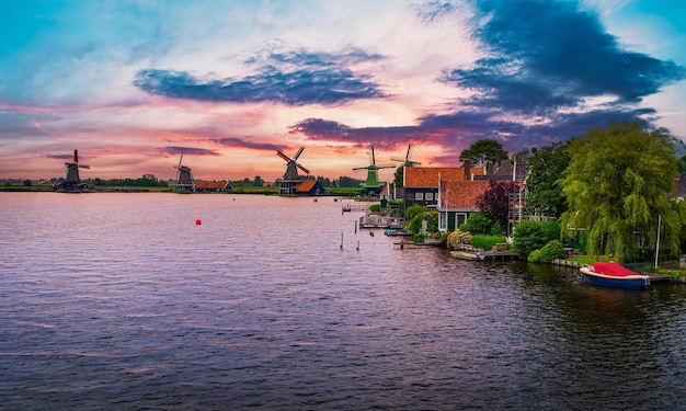 Sunset above farm houses and windmills of zaanse schans in the netherlands