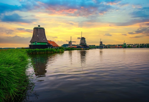 Sunset above farm houses and windmills of zaanse schans in the netherlands