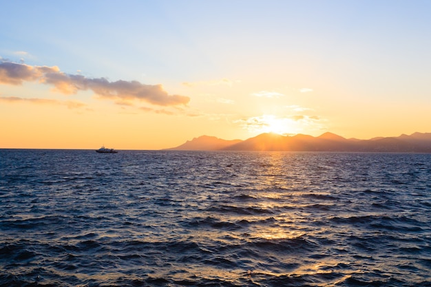 Sunset from the port of Cannes, France. Beautiful french panorama. Sun over Esterel mountains