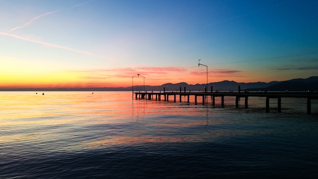 Sunset at Garda lake, Italy. Italian landscape. Pier in perspective