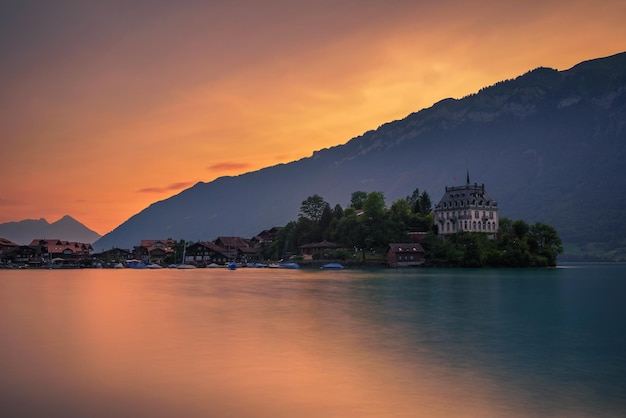 Sunset above Iseltwald peninsula and former castle in Switzerland