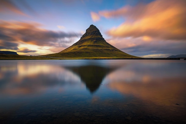 Sunset over Kirkjufell mountain with reflection in a nearby lake in Iceland