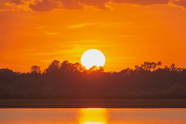 Sunset in the lake. beautiful sunset behind the clouds above the over lake landscape