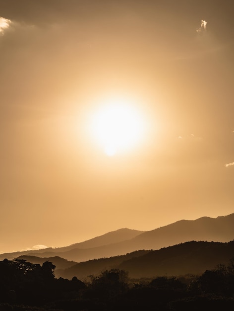 Sunset landscape with mountain and sun gold lighting under vibrant colorful evening sky in mountains Nature mountain sky and clouds sunset concept