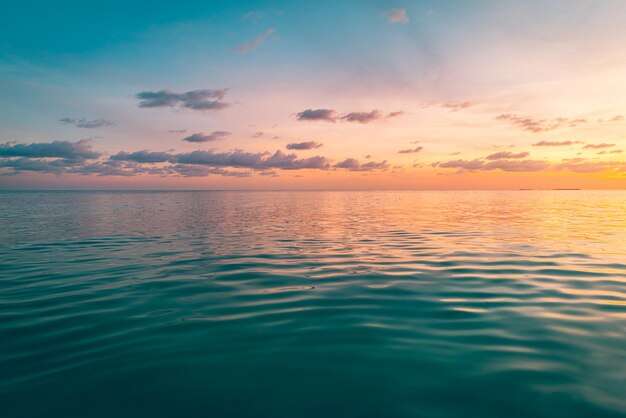 Photo a sunset over the ocean with a sky and clouds