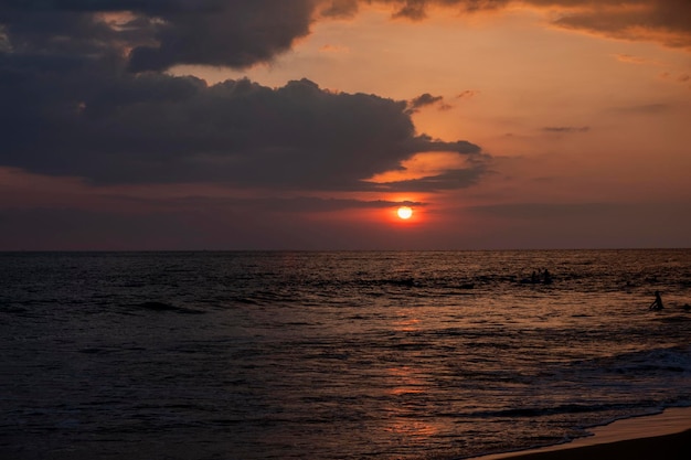 Sunset on the ocean with surfers in sri lanka