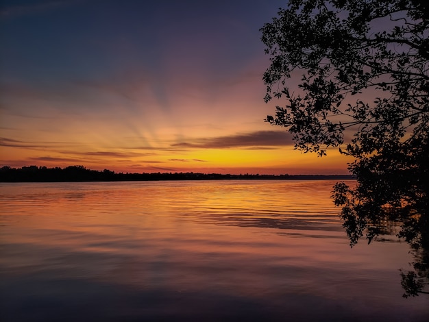 Sunset on the river in the summer and wooden pier