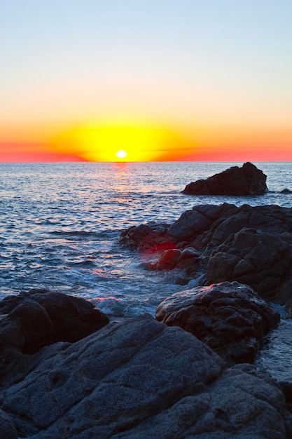 Sunset on the rocky shore. Tyrrhenian Sea sunset in Calabria, Italy.