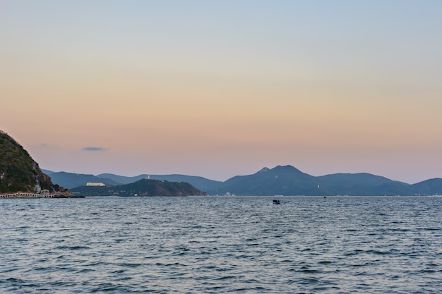 Sunset, sand, clear turquoise sea, coral reefs on the coast of Xiaodonghai Bay in South China Sea. Sanya, island Hainan, China. Nature Landscape.