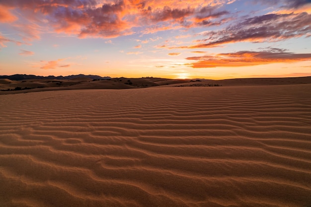 Sunset over the sand dunes in the desert Arid landscape of the Sahara desert