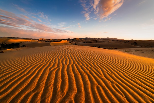 Sunset over the sand dunes in the desert Arid landscape of the Sahara desert